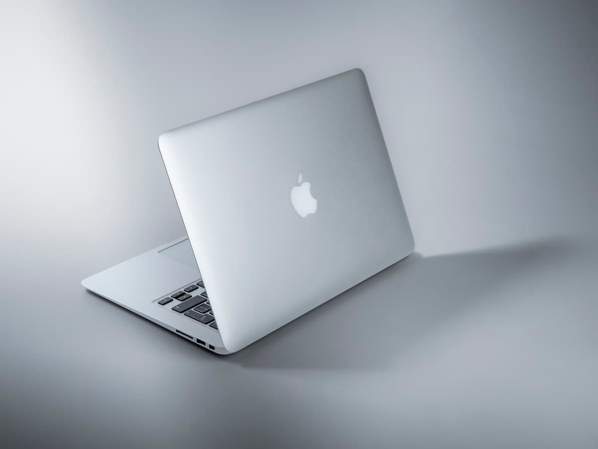 A silver MacBook open on a clean workbench